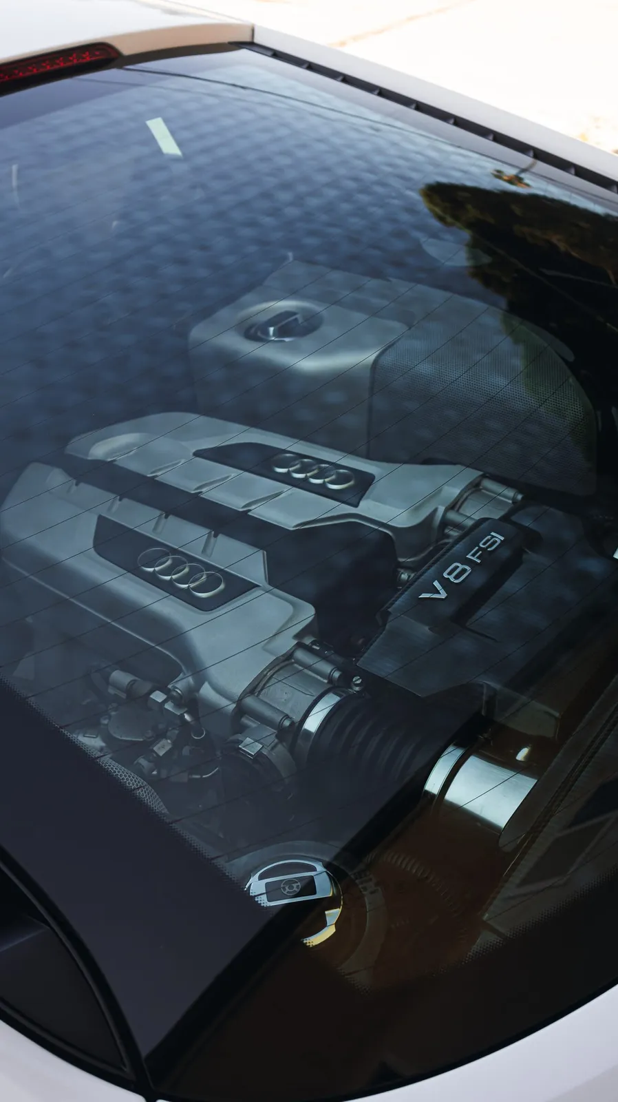 Clean V8 engine bay after detailing, reflected in the rear glass