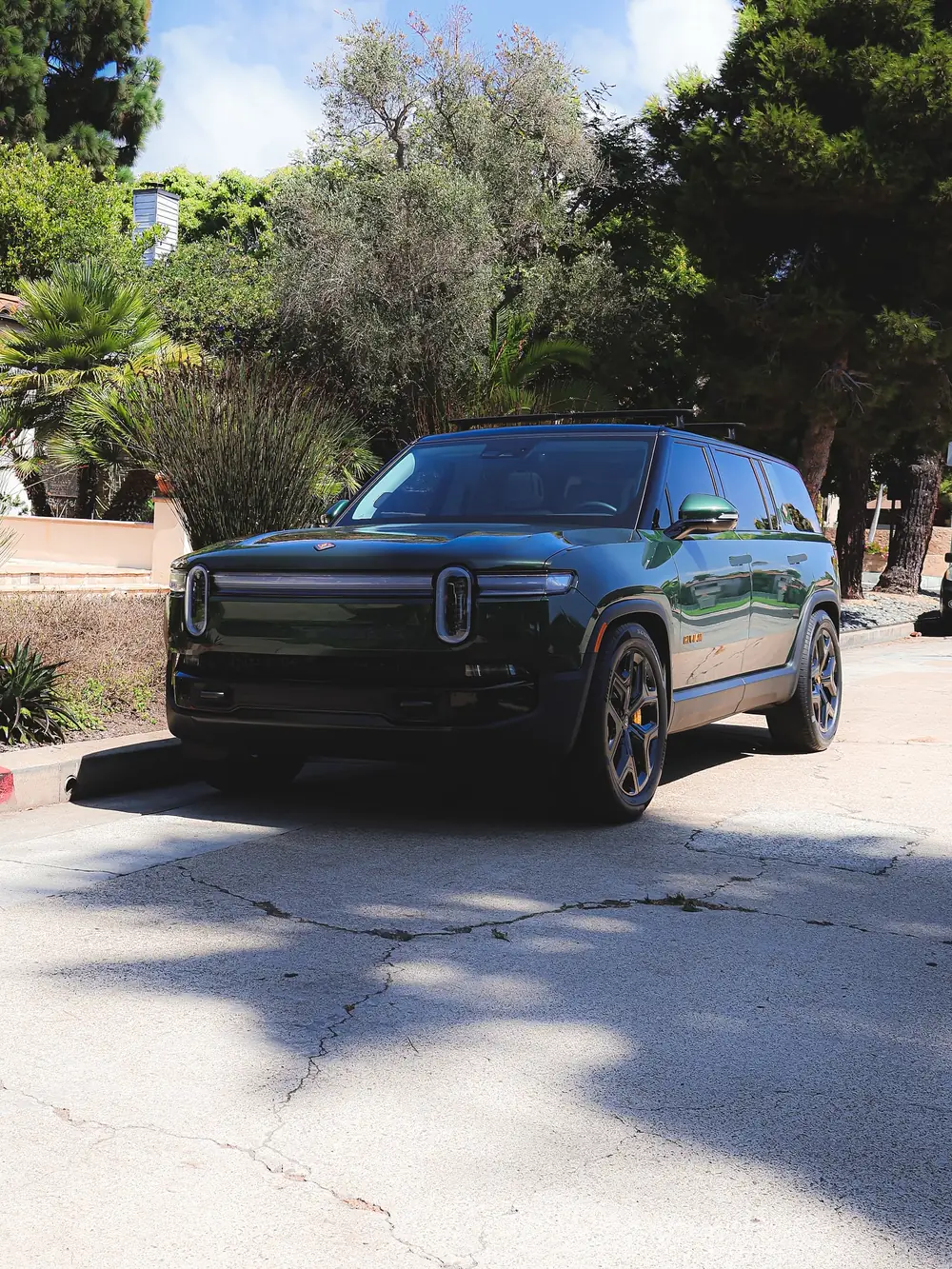 Blossom Valley paint correction: green Rivian R1S parked in a driveway under trees