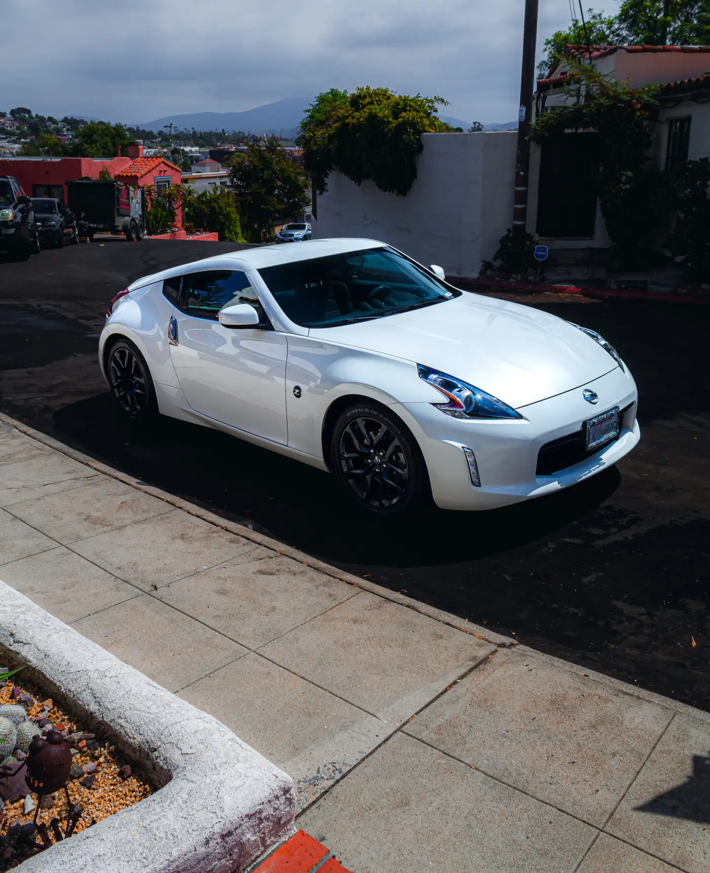 Chula Vista paint correction: glossy white Nissan 370Z parked on a hillside street